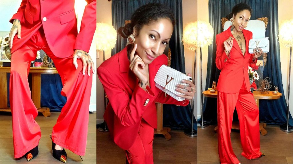 A woman donning a striking all red suit, inspired by Valentino, confidently posing for a photo