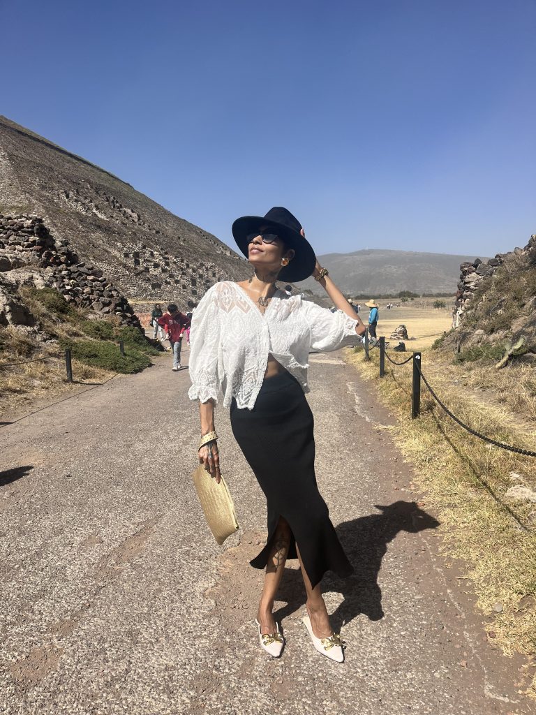 Behold the allure of a refined woman in Mexico, adorned in a lace top and a luxurious suede hat. Her poised stance and impeccable style leave a lasting impression.