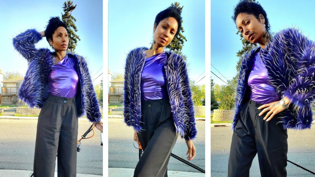 Elegant woman in purple shirt and black pants, showcasing a luxurious style with a faux fur jacket.