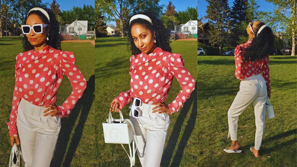  A chic woman exudes elegance in a pink polka dot chiffon blouse, paired flawlessly with a high waist white corset pant in the park.