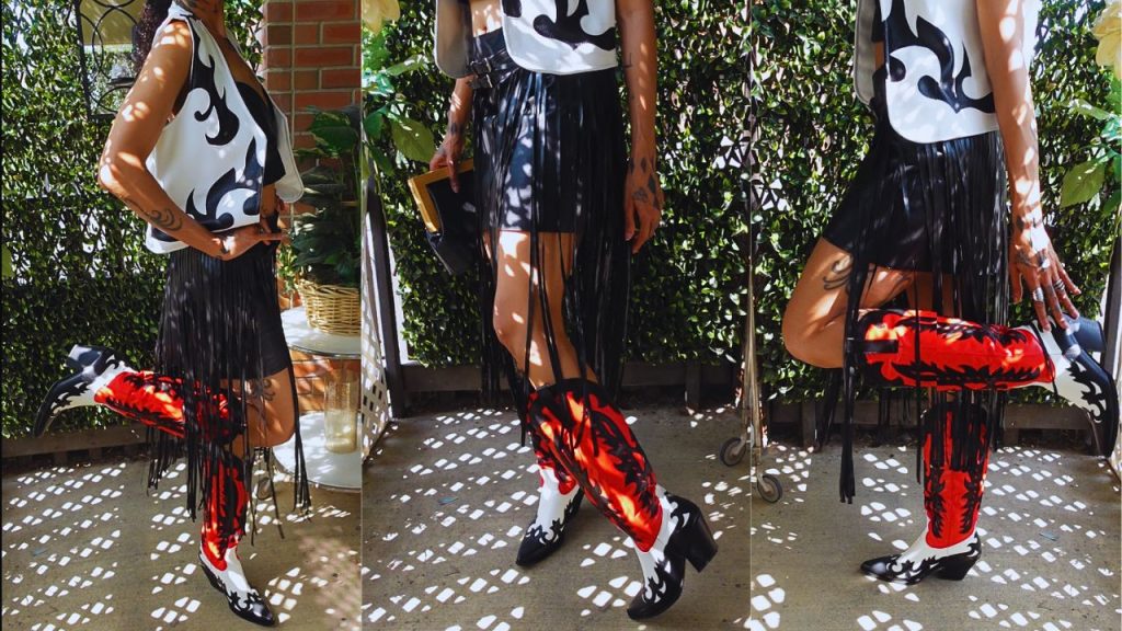 A stylish woman in a white shirt and western leather skirt, showcasing her chic cowboy boots with confidence.